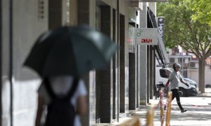 15/06/2022 Una joven camina por una calle bajo un termómetro que indica los 47ºC este miércoles, tercer día de ola de calor en Cataluña, que, según las previsiones, aún será más sofocante mañana, para alcanzar su máximo el viernes, a 15 de junio de 2022,