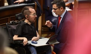 El portavoz de Unidas Podemos en el Congreso, Pablo Echenique (i), y el ministro de Presidencia, Félix Bolaños, conversan en una sesión de control, en el Congreso de los Diputados. E.P./Eduardo Parra