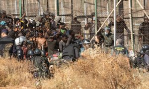 29/06/2022 Un miembro de las fuerzas de seguridad marroquí se lleva detenido a un migrante desde el lado español de la frontera con Melilla