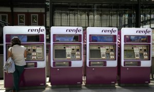 Una mujer saca unos billetes de Renfe en la estación madrileña de Príncipe Pío.