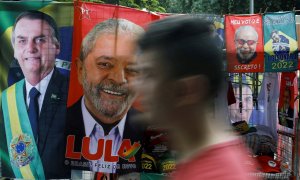 20/07/2022-Un hombre pasa junto a toallas expuestas y materiales de campaña presidencial que representan al ex presidente de Brasil Luiz Inacio Lula da Silva y al presidente de Brasil Jair Bolsonaro, en Río de Janeiro, Brasil, 20 de julio de 2022.