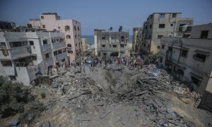 palestinos inspeccionan una casa destruida que pertenece a la familia Shamlakh tras los ataques aéreos israelíes en el sur de la ciudad de Gaza.