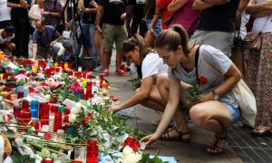 Dues noies encenen espelmes a les Rambles, en un dels punts improvisats de record a les víctimes dels atemptats el 20 d'agost de 2017, pocs dies després de l'atemptat.