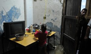 Fotografía de archivo fechada el 10 de septiembre de 2008 que muestra a una niña mientras lava platos en una improvisada cocina en el poblado José Martí, municipio de San Cristóbal, provincia de Pinar del Río