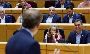 El presidente del Gobierno, Pedro Sánchez (d), y la vicepresidenta primera y ministra de Asuntos Económicos y Transformación Digital, Nadia Calviño (c), escuchan la intervención del líder del PP, Alberto Núñez Feijóo (i), durante el pleno del Senado cele