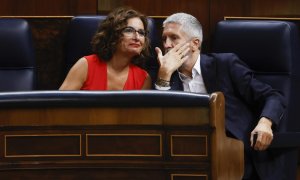 El ministro del Interior, Fernando Grande-Marlaska (d) conversa con la ministra de Hacienda, María Jesús Montero (i) durante la sesión de control al gobierno celebrada este miércoles en el Congreso