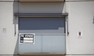 Cartel de se vende en el balcón de un piso de un edificio de Madrid.