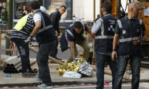 Agentes de Policía cubren el cadáver de un trabajador fallecido en accidente laboral e inspeccionan la escena.