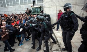 01/10/2017 - Agents de la Guàrdia Civil empenten votants a l'escola de Sant Julià de Ramis durant l'1-O de 2017.