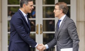 El presidente del Gobierno, Pedro Sánchez (i), recibe al líder del PP, Alberto Núñez Feijóo (d), antes de su reunión en La Moncloa, este lunes.