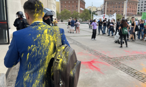 Un congressista tacat de pintura quan entrava a The District, amb manifestants al fons