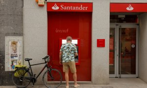 Un hombre utiliza el cajero automático de una oficina del Banco Santander en Ronda (Málaga). REUTERS/Jon Nazca