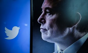 Una vista del logotipo de la empresa estadounidense de redes sociales Twitter en la pantalla de un teléfono inteligente junto a un retrato del empresario Elon Musk. Acciones de Twitter