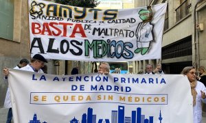 Varias personas con una pancarta durante una concentración frente a la consejería de Sanidad.