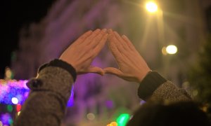 Una mujer hace el histórico gesto feminista durante la marcha del 25N por Madrid.