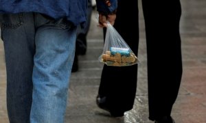 un hombre lleva una bolsa con monedas, en Ronda (Málaga). REUTERS/Jon Nazca