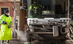 Un trabajador de la limpieza utiliza agua a presión para limpiar las aceras.