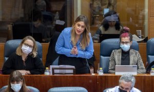 Carolina Alonso, Alejandra Jacinto (de pie) y Vanesa Lillo, portavozas de Unidas Podemos en la Asamblea de Madrid