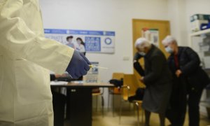 Imagen de archivo de un enfermero preparado para administrar la vacuna de la gripe a dos mujeres.