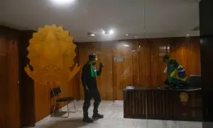 Dos ultras con banderas en una habitación del Palacio presidencial de Brasil, en Brasilia, tras el asalto.