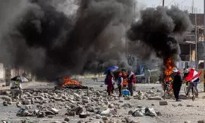 Varias personas caminan entre barricadas durante una manifestación en la ciudad de Tacna, a 11 de enero de 2023.