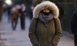 Una mujer pasea por Madrid cuando la capital se encuentra en aviso amarillo por temperaturas mínimas.