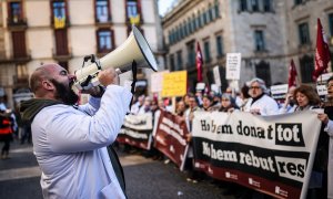 Un facultatiu crida proclames en la manifestació convocada per Metges de Catalunya a la plaça Sant Jaume.