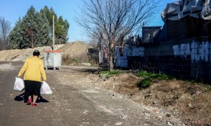 Una mujer camina cargada con bolsas en la Cañada Real, a 31 de diciembre de 2021, en Madrid, (España).