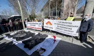 Varias personas participan durante una ‘performance’, de Marea de Residencias y Verdad y Justicia, para protestar por los fallecimientos de mayores durante la pandemia, en las puertas de la Asamblea de Madrid, a 2 de marzo de 2023, en Madrid (España).