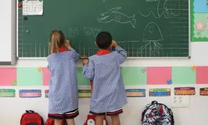 Dos niños pintan en una pizarra el día de inicio del curso en el colegio de la Alameda de Osuna, a 5 de septiembre de 2022, en Madrid (España)