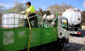 Un operari omple un dipòsit amb aigua freàtica provinent del camió cisterna al Parc de la Ciutadella de Barcelona.