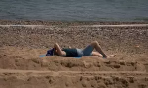 26/04/2023. Una mujer toma el sol en la playa de la Barceloneta, a 25 de abril de 2023, en Barcelona.