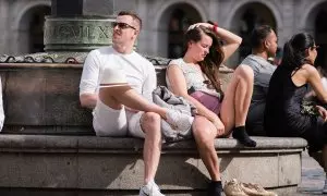 Dos personas se sientan al sol, a 24 de abril de 2023, en Madrid (España).