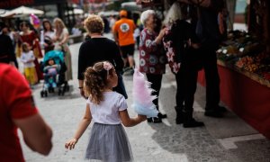 Una niña con un algodón de azúcar en el mercadillo, de la Feria Medieval de El Álamo, a 30 de abril de 2022