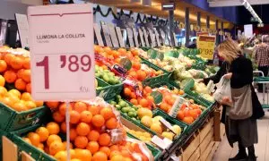 Una clienta compra pomes en una gran superfície en una secció on els productes han passat a estar gravats del 4% al 0%.