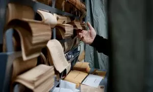 Un hombre escoge papeletas en el colegio electoral de Chozas de la Sierra en Soto del Real, Madrid, este domingo durante las elecciones municipales y autonómicas.