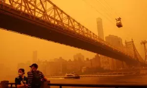 Gente usando máscaras protectoras mientras el tranvía de Roosevelt Island cruza el East River.