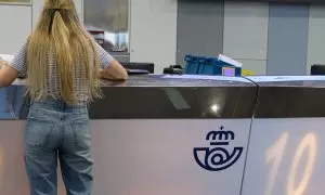 Una chica en el mostrador de la oficina de Correos de Cibeles, a 1 de junio de 2023, en Madrid.