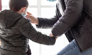 Una madre coloca a su hijo una mascarilla un día después de que el presidente del Gobierno, Pedro Sánchez, haya confirmado en una rueda de prensa que los niños podrán salir a la calle "con condiciones" a partir del 27 de abril, en Vitoria/Euskadi (España)