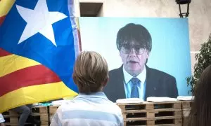 Un niño observa la intervención telemática de Puigdemont en el mitin central del partido JxCAT, a 16 de julio de 2023, en en Amer, Girona, Catalunya (España). Junts per Catalunya ha elegido la ciudad natal del expresidente de la Generalitat y de la formac