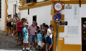 Personas haciendo cola en la sombra para evitar el fuerte sol, en Ronda, a 7 de agosto.