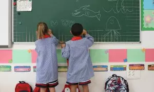 Dos niños pintan en una pizarra el día de inicio del curso en el colegio de la Alameda de Osuna, a 5 de septiembre de 2022, en Madrid (España).