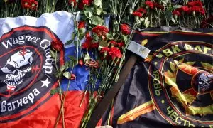 Banderas y un mazo con el logotipo de Wagner entre las flores colocadas en un monumento improvisado cerca de la antigua sede del grupo de mercenarios en la ciudad rusa de San Petersburgo. REUTERS/Anastasia Barashkova