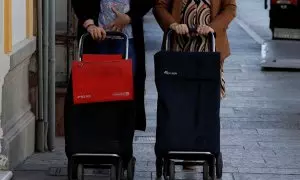 Dos mujeres llevan sus carros de la compra en la localidad malagueña de Ronda. REUTERS/Jon Nazca