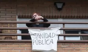 Una vecina coloca una pancarta que reza 'Sanidad Pública' para apoyar una manifestación por la sanidad pública en Villa de Vallecas, a 5 de marzo de 2023, en Madrid (España).