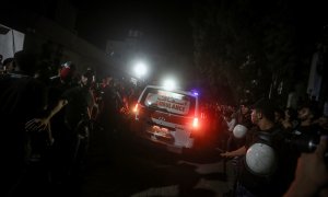 Una ambulancia traslada el cuerpo de un joven palestino muerto en la explosión en la valla de Gaza.