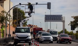 Un técnico monta una cámara de tráfico en un semáforo para controlar el acceso a la Zona de Bajas Emisiones (ZBE) de Madrid.