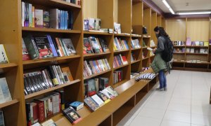 Una clienta de la llibreria La Capona de Tarragona remenant llibres. Foto: ACN/Eloi Tost