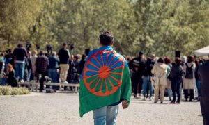 Una persona con una bandera gitana a su espalda durante el acto conmemorativo del Día Internacional del Pueblo Gitano el 13 de abril de 2023. Gabriel Luengas / Europa Press