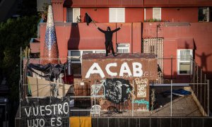 Un ocupa oneja una bandera negra al terrat d'El Kubo, un dels dos edificis desallotjats aquest dijous.